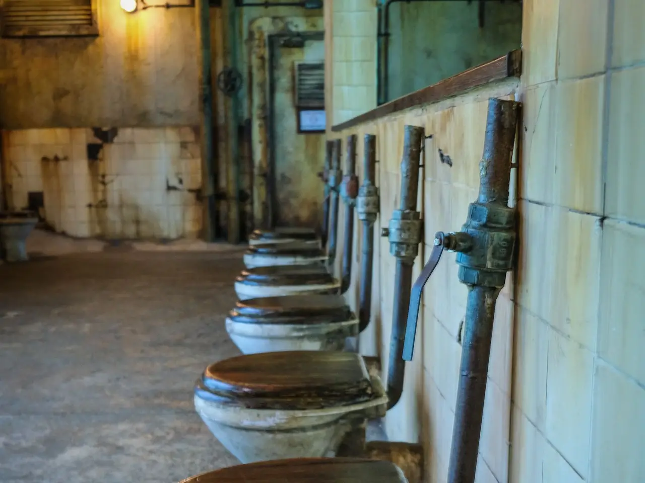 Example before: worn old toilets with exposed pipes